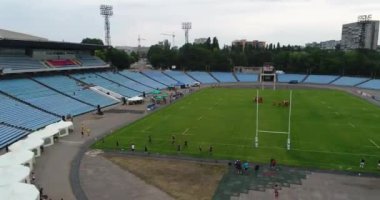 Dişi rugby oyuncuları stadyum meteorları eğitiyorlar. Dnipro panoramik gökyüzü drone helikopteri.