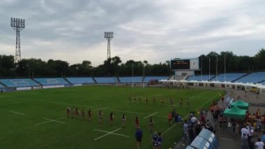 Dişi rugby oyuncuları stadyum meteorları eğitiyorlar. Dnipro panoramik gökyüzü drone helikopteri.