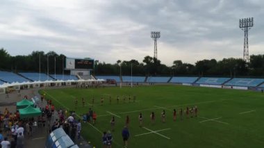 Dişi rugby oyuncuları stadyum meteorları eğitiyorlar. Dnipro panoramik gökyüzü drone helikopteri.