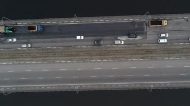 Arabalar nehrin üzerindeki iki köprüye binerler. Kamera aşağı doğru daha yüksek bir yüksekliğe yükselir ve döner. Hava panoramik üst görünümü uçan gökyüzü görüntüsü İHA ile çekim.