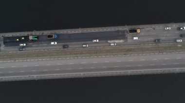 Arabalar nehrin üzerindeki iki köprüye binerler. Kamera aşağı doğru daha yüksek bir yüksekliğe yükselir ve döner. Hava panoramik üst görünümü uçan gökyüzü görüntüsü İHA ile çekim.