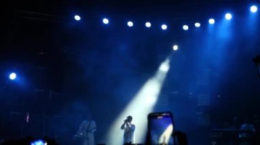 Konser sırasında havada süzülen konfeti bir konserde ışıkları aydınlatıyor.