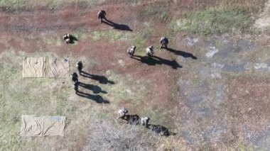 Denizci eğitim subayı üç stajyeri atış poligonunda şınav çekerken izliyor.