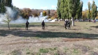 Denizci eğitim subayı üç stajyeri atış poligonunda şınav çekerken izliyor.