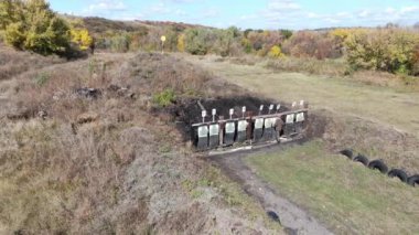 Denizci eğitim subayı üç stajyeri atış poligonunda şınav çekerken izliyor.