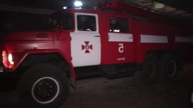 Şehir caddesinde yangın söndürücüyle yangını söndürmeye çalışan ama içerisi tamamen yanmış bir araba yangını.