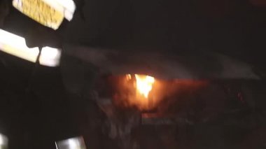 Şehir caddesinde yangın söndürücüyle yangını söndürmeye çalışan ama içerisi tamamen yanmış bir araba yangını.