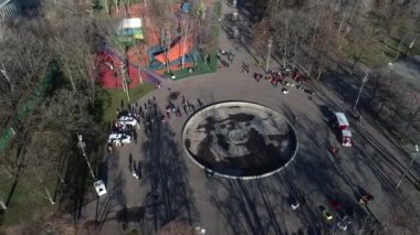 Dnipro, Ukrayna - Devriye arabası şehir parkındaki ağaçların arkasına park edilmiş. Ilık bahar günü. Çevredeki ağaçlarda taze yeşiller