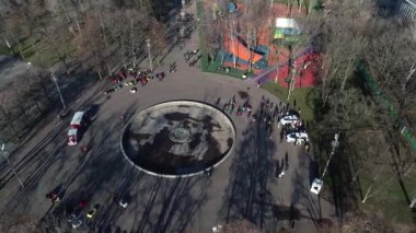 Dnipro, Ukrayna - Devriye arabası şehir parkındaki ağaçların arkasına park edilmiş. Ilık bahar günü. Çevredeki ağaçlarda taze yeşiller