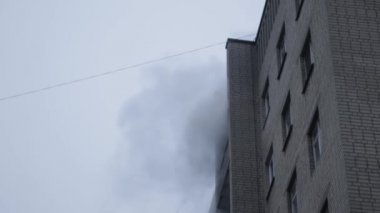 Genel apartman binası, dükkan tentelerinin üzerinde DX gündüz çekim yapan dış cephe. Tuğla cephede pencereden yangın çıkışı