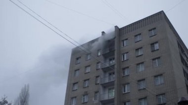 Genel apartman binası, dükkan tentelerinin üzerinde DX gündüz çekim yapan dış cephe. Tuğla cephede pencereden yangın çıkışı