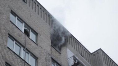 Genel apartman binası, dükkan tentelerinin üzerinde DX gündüz çekim yapan dış cephe. Tuğla cephede pencereden yangın çıkışı