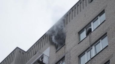 Genel apartman binası, dükkan tentelerinin üzerinde DX gündüz çekim yapan dış cephe. Tuğla cephede pencereden yangın çıkışı
