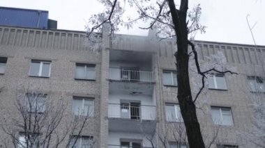 Genel apartman binası, dükkan tentelerinin üzerinde DX gündüz çekim yapan dış cephe. Tuğla cephede pencereden yangın çıkışı