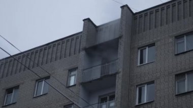 Genel apartman binası, dükkan tentelerinin üzerinde DX gündüz çekim yapan dış cephe. Tuğla cephede pencereden yangın çıkışı
