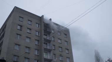 Genel apartman binası, dükkan tentelerinin üzerinde DX gündüz çekim yapan dış cephe. Tuğla cephede pencereden yangın çıkışı