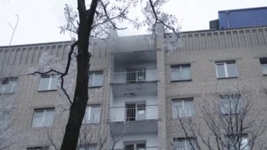 Genel apartman binası, dükkan tentelerinin üzerinde DX gündüz çekim yapan dış cephe. Tuğla cephede pencereden yangın çıkışı