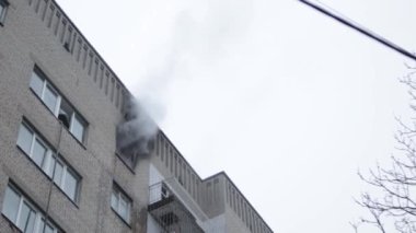 Genel apartman binası, dükkan tentelerinin üzerinde DX gündüz çekim yapan dış cephe. Tuğla cephede pencereden yangın çıkışı