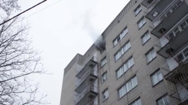 Genel apartman binası, dükkan tentelerinin üzerinde DX gündüz çekim yapan dış cephe. Tuğla cephede pencereden yangın çıkışı