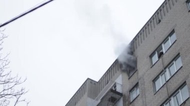 Genel apartman binası, dükkan tentelerinin üzerinde DX gündüz çekim yapan dış cephe. Tuğla cephede pencereden yangın çıkışı