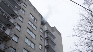 Genel apartman binası, dükkan tentelerinin üzerinde DX gündüz çekim yapan dış cephe. Tuğla cephede pencereden yangın çıkışı