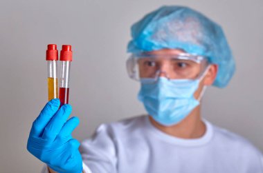Koronavirüs COVID19, HIV, ebola ya da diğer tehlikeli enfeksiyonlar için kan testi yapan maskeli bir doktor. Doktor portresi, tıbbi geçmiş, şablon, duvar kağıdı. Coronavirus hastalığı 