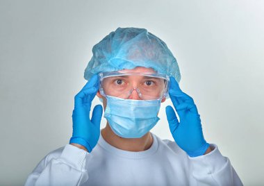 Kafasını tutan maskeli bir doktor, tıbbi geçmişi, duvar kağıdı. Coronavirus hastalığı COVID19, hastane, karantina, analiz konsepti. Doktor portresi