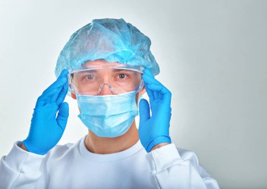 Kafasını tutan maskeli bir doktor, tıbbi geçmişi, duvar kağıdı. Coronavirus hastalığı COVID19, hastane, karantina, analiz konsepti. Doktor portresi