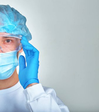 Kafasını tutan maskeli bir doktor, tıbbi geçmişi, duvar kağıdı. Coronavirus hastalığı COVID19, hastane, karantina, analiz konsepti. Doktor portresi