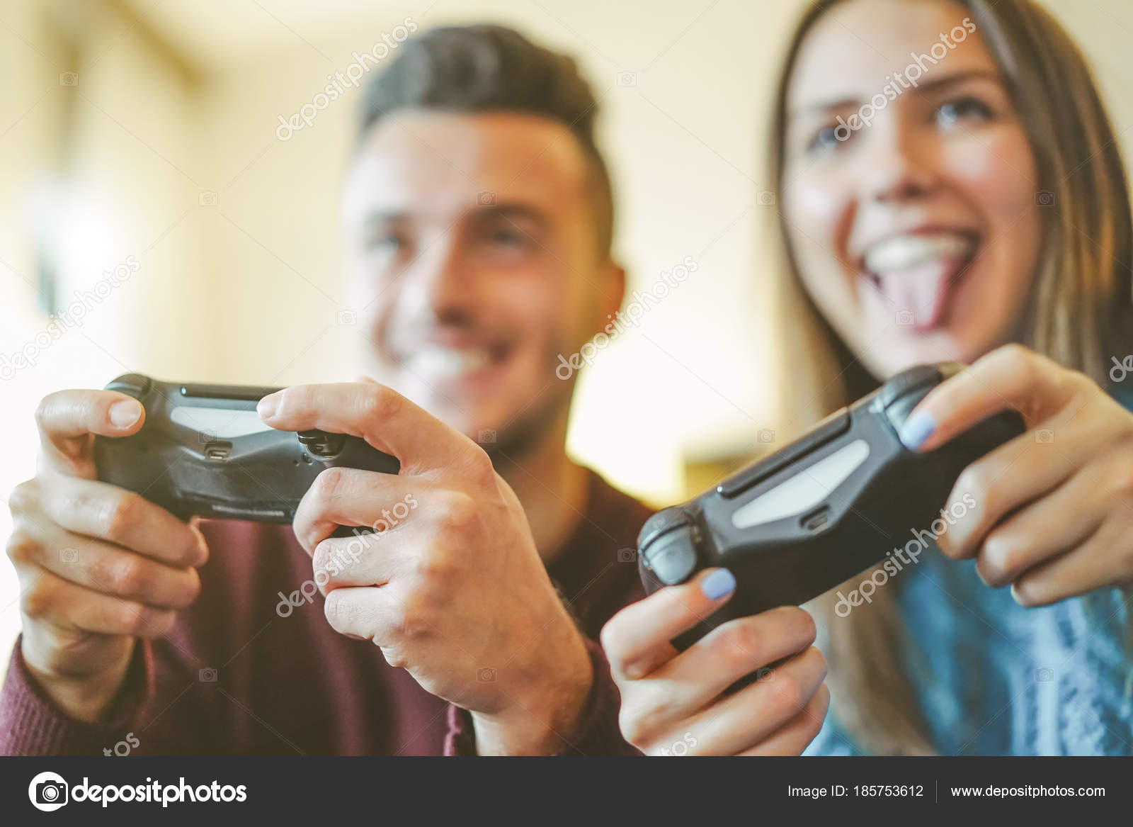 Happy Couple Sitting on the Sofa Playing Video Games, Using Controllers.  Competitive Girlfriend and Boyfriend in Love have Fun Playing in Online  Video Games at Home Together. Close-up Focus on Hands Stock
