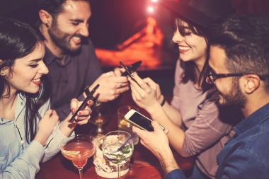 Cep telefonu kullanarak ve bir Jazz - genç insanlar için yeni smartphone teknoloji bağımlısı - bar kokteyller ile eğlenmek mutlu arkadaşlar kavramı gençlik, cep telefonu ve yaşam tarzı - odak şu erkek yandan