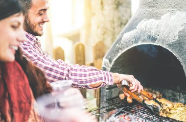 Bir Barbekü partisi yapmak mutlu genç arkadaşlar et - yakışıklı arkadaşları için ızgara sığır eti yemek - arka bahçesinde ızgara kavramı insanların, gıda, yaşam tarzı ve dostluk - odak erkek yandan