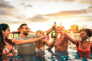 Bir havuz partisi gençlik yaşam tarzı kavramı - köpüklü şarap lüks tropikal tatil ile toasting gençler gülen ve having fun - gün batımında şampanya ile tezahürat yapmak mutlu arkadaş grubu