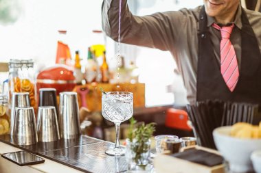 Bir kokteyl bir kristal cam içinde bir Amerikan bar - aromatik otlar - meslek, yaşam tarzı ile bir bardak barmen dökme alkol karışımı barmen konsept iç