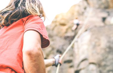 Adam onu ip - dağcı rock yakınındaki tepe - hırs, adrenalin, eylem içinde tutarak en tepeye tırmanmaya yardım ederken dağ cliff üzerinde yukarı tırmanma kadın kavramı spor