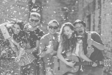 Mutlu arkadaş sokak gitar çalmak ve konfeti - komik insanlar dostluk - siyah ve beyaz Düzenle - kavramı atma sırasında müzik dinlemek bir parti yapma eğleniyor grubu arka plan Defocused