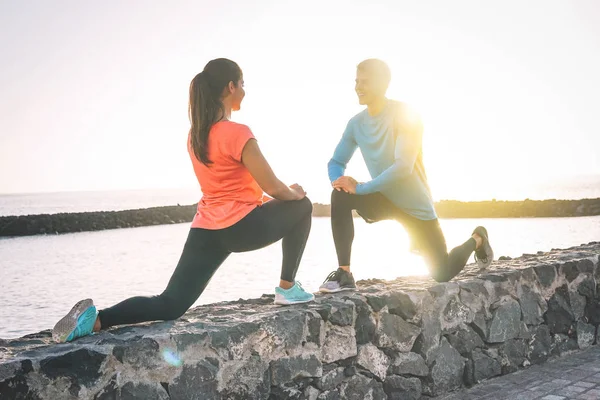 Ung Hälsa Par Stretching Benen Intill Stranden Solnedgången Glada Sportiga — Stockfoto