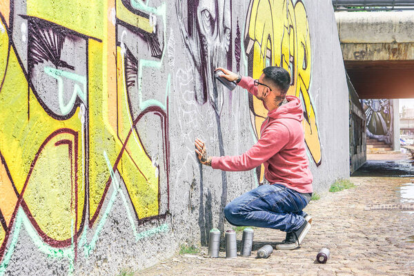 Уличные граффити художника живопись с цветным спреем может темный монстр череп граффити на стене в городе на открытом воздухе - городской, образ жизни современная концепция уличного искусства - Главное внимание на его руку
