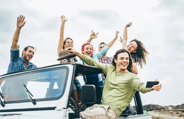 ジープ車 若い人々 と楽しくモバイル スマート フォンと Selfie を取って幸せな友人のグループ写真を作る道路の旅 滞在中に 青年休日ライフ スタイルのコンセプト — ストック写真