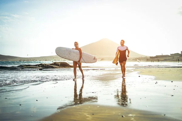 Surfers Ζευγάρι Τρέχει Μαζί Ιστιοσανίδες Στην Παραλία Ηλιοβασίλεμα Σπορ Φίλους — Φωτογραφία Αρχείου