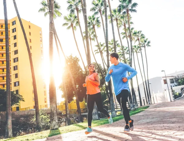 Healthy young couple jogging together  at sunset time outdoor - People work out - Relationship, sport, lifestyle concept