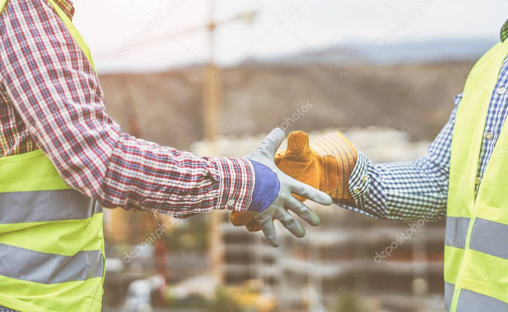 Close up builders hands making a deal - Workers on construction site reaching an agreement - Building, dealing, enginner industrial concept
