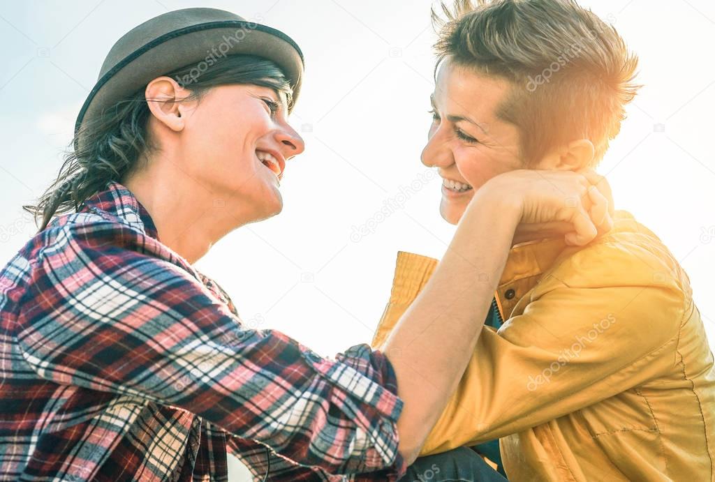 Happy gay couple looking at each other hand to hand - Young women lesbians having a tender moment outdoor - Lgbt, bisexuality, relationhsip lifestyle concept