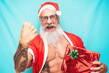 Noel hediyesi taşıyan mutlu zinde Noel Baba - son sınıf öğrencisi - Noel bayramını kutlarken eğleniyor - yaşlılar ve geleneksel yaşam tarzı kültürü