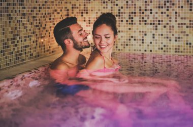 Mutlu çift yüzme havuzunda lüks spa tatil köyünde eğleniyor Romantik gençler birlikte rahatlıyor - aşk ilişkisi kavramı