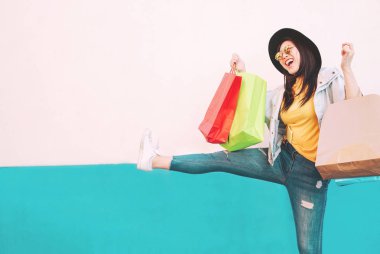 Asyalı moda kızı alışveriş merkezinde alışveriş yapıyor - mutlu Çinli kadın tatilde yeni kıyafetler alırken eğleniyor - tüketim, insan ve gençlik yaşam tarzı konsepti