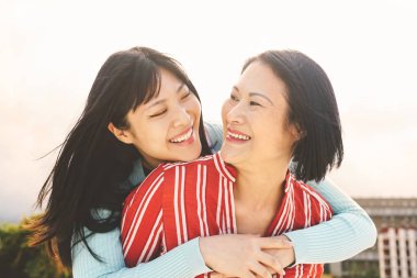 Mutlu Asyalı anne ve kızı dışarıda eğleniyor Çinliler dışarıda birlikte vakit geçiriyor sevgi, ilişki ve ebeveynlik yaşam tarzı kavramı.