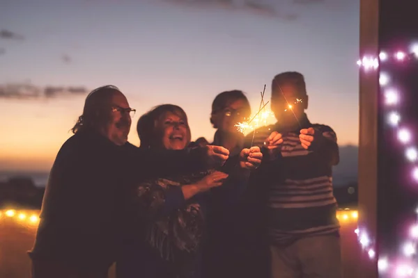 Personas mayores amigos divirtiéndose celebrando vacaciones juntos al aire libre - Personas mayores felices disfrutando de la fiesta riendo en la terraza al atardecer - Estilo de vida de las personas mayores actividad y cultura concepto de evento — Foto de Stock