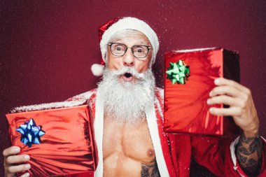 Noel Baba 'nın elinde Noel hediyeleri var - hippi sakallı son sınıf öğrencisi Noel' i kutlayan xmas kıyafetleri giyerek eğleniyor - yaşlılar ve geleneksel yaşam tarzı kültürü