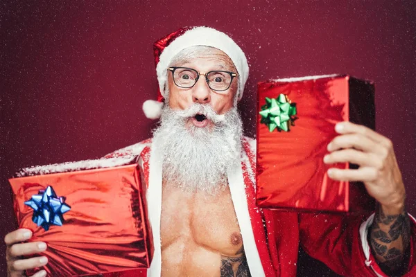 Fröhliche Weihnachtsmänner mit Weihnachtsgeschenken - hippe bärtige Senioren, die Spaß daran haben, Weihnachten in Weihnachtskleidung zu feiern - ältere Trendmenschen und traditionelle Lifestylekultur — Stockfoto